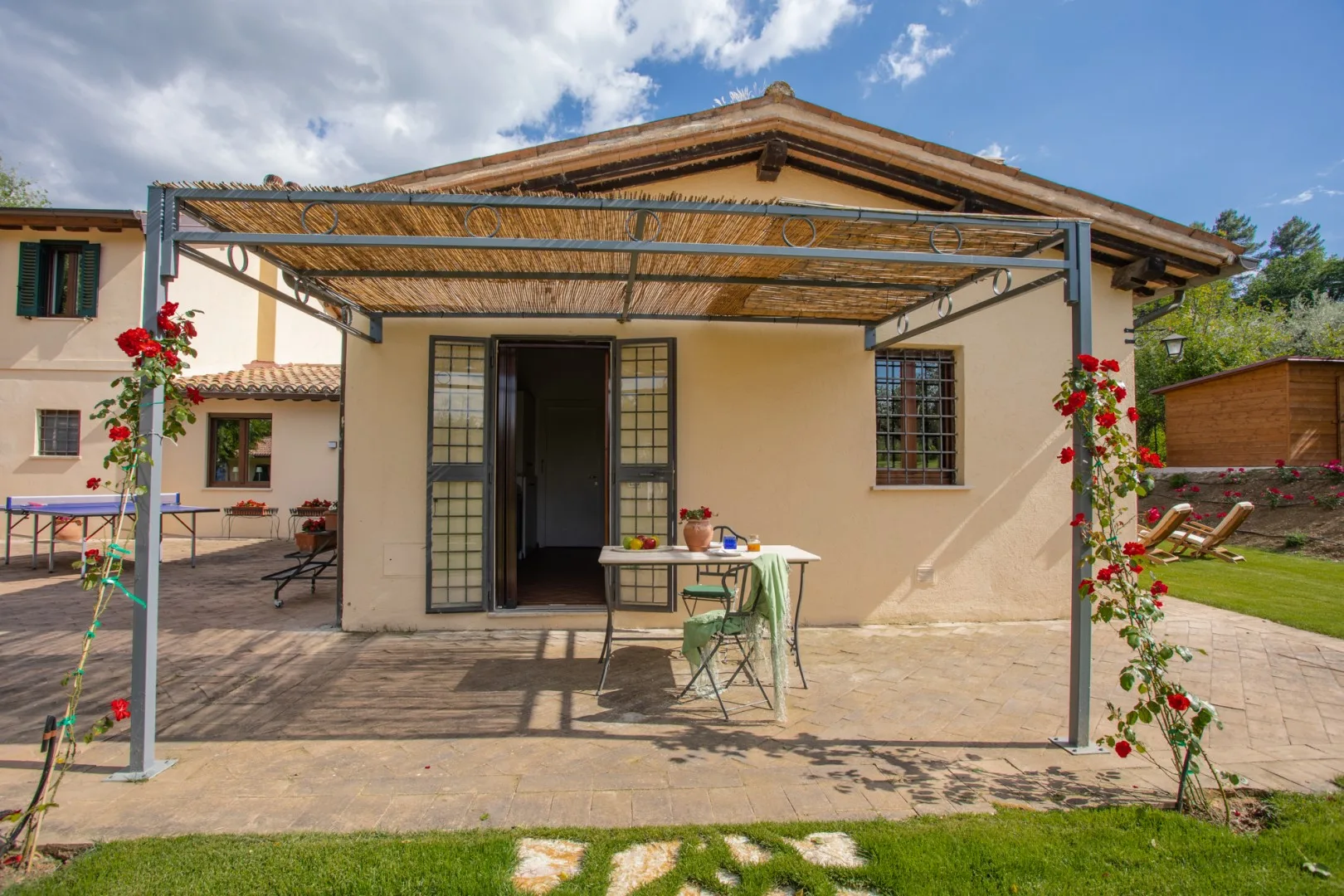 A house patio with a shaded pergola and outdoor table.