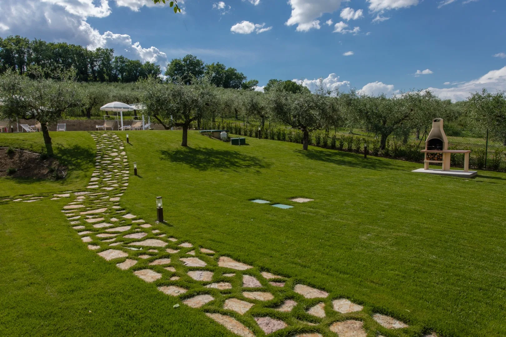 A landscaped garden with a stone path winding across the lawn.