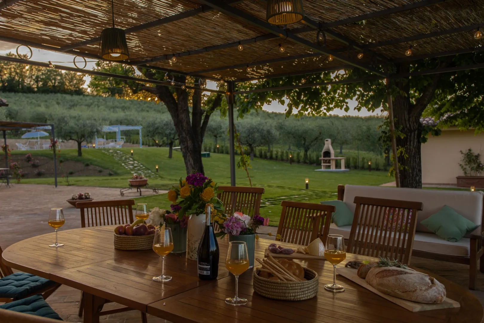A covered outdoor dining area overlooks a green garden.