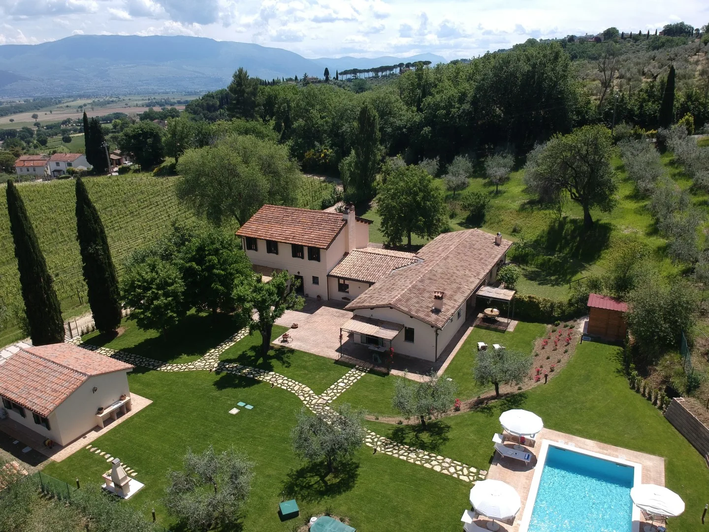 A countryside property with a house, garden, and swimming pool.