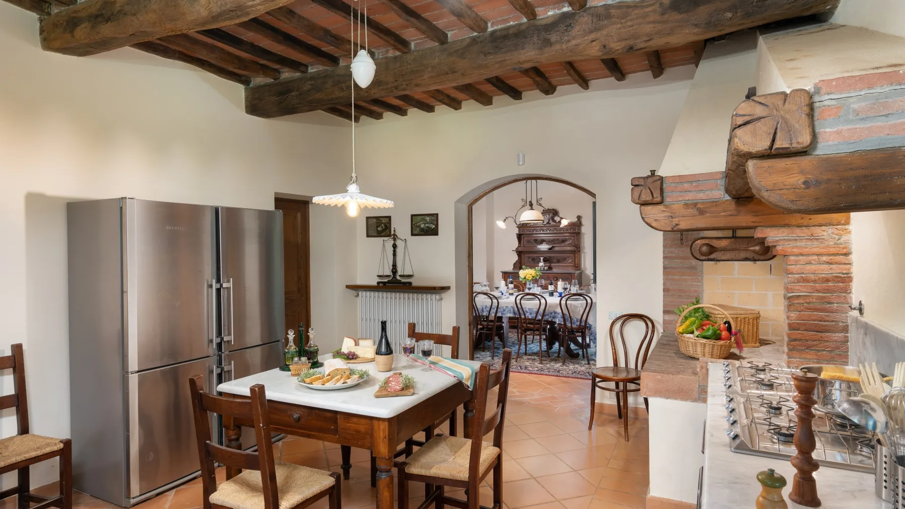 Una cocina y comedor rústicos con vigas de madera expuestas y una mesa de madera.