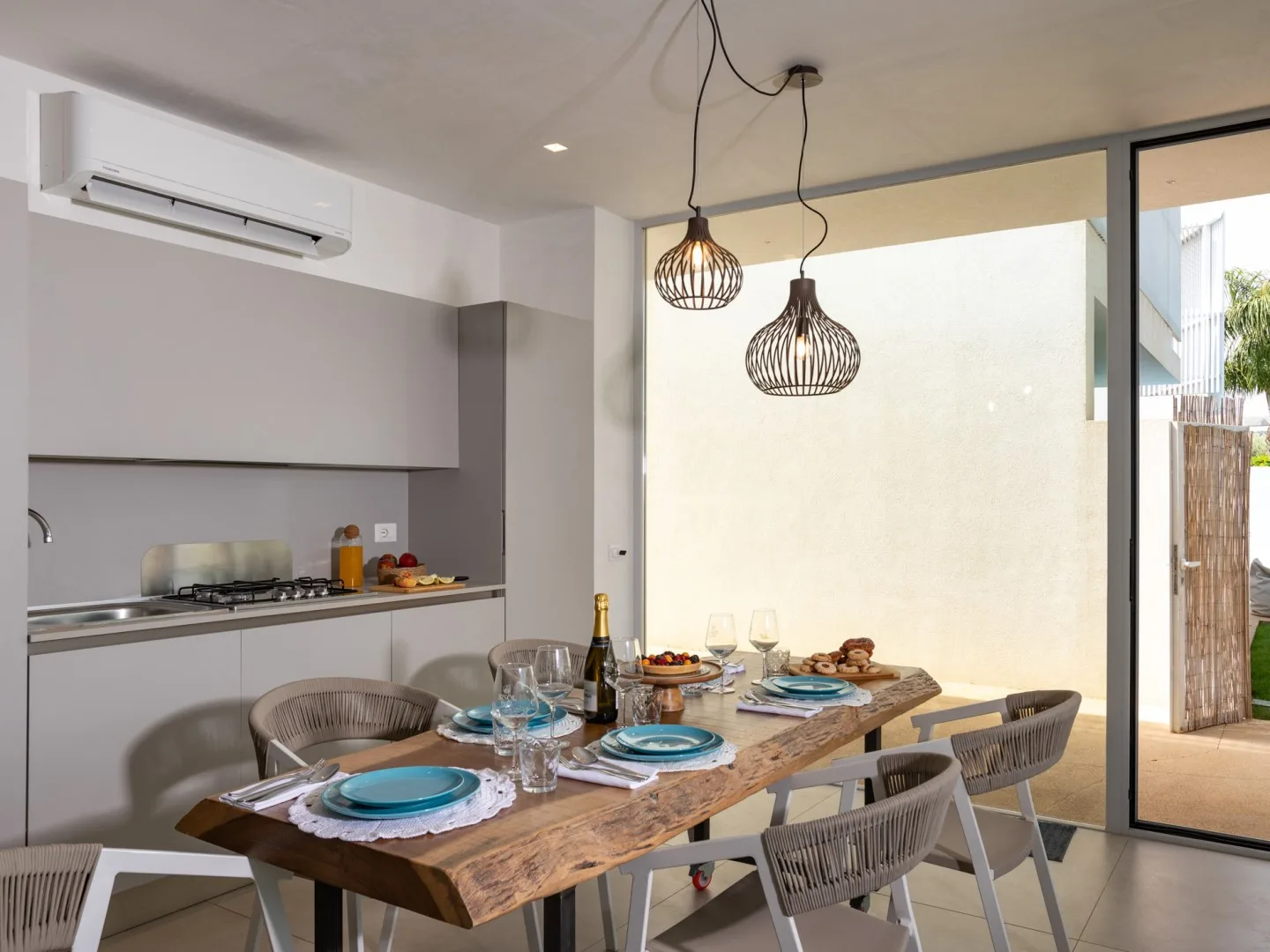 Comedor con una mesa de madera preparada con platos y vasos.