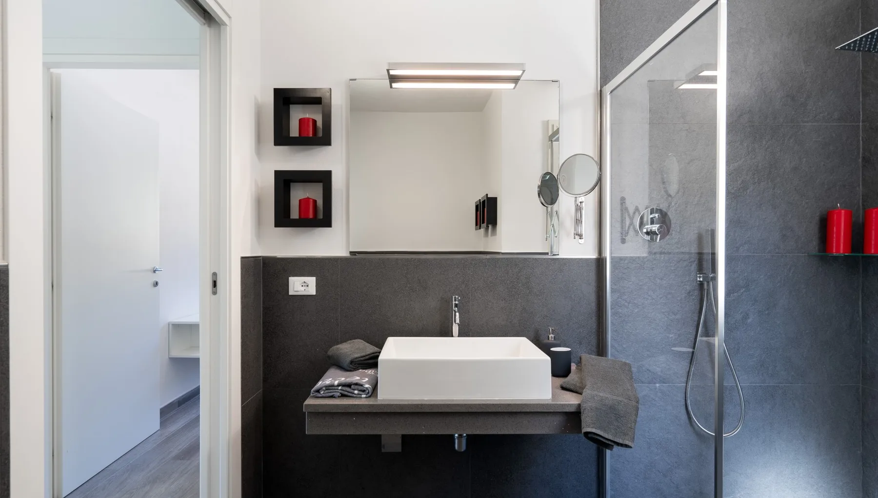 Un baño moderno con un lavabo rectangular bajo un espejo grande.