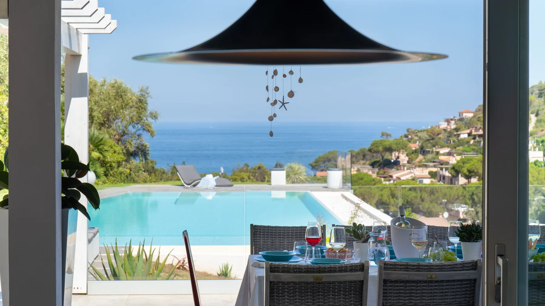 Un comedor se abre a una piscina y a una vista del mar.