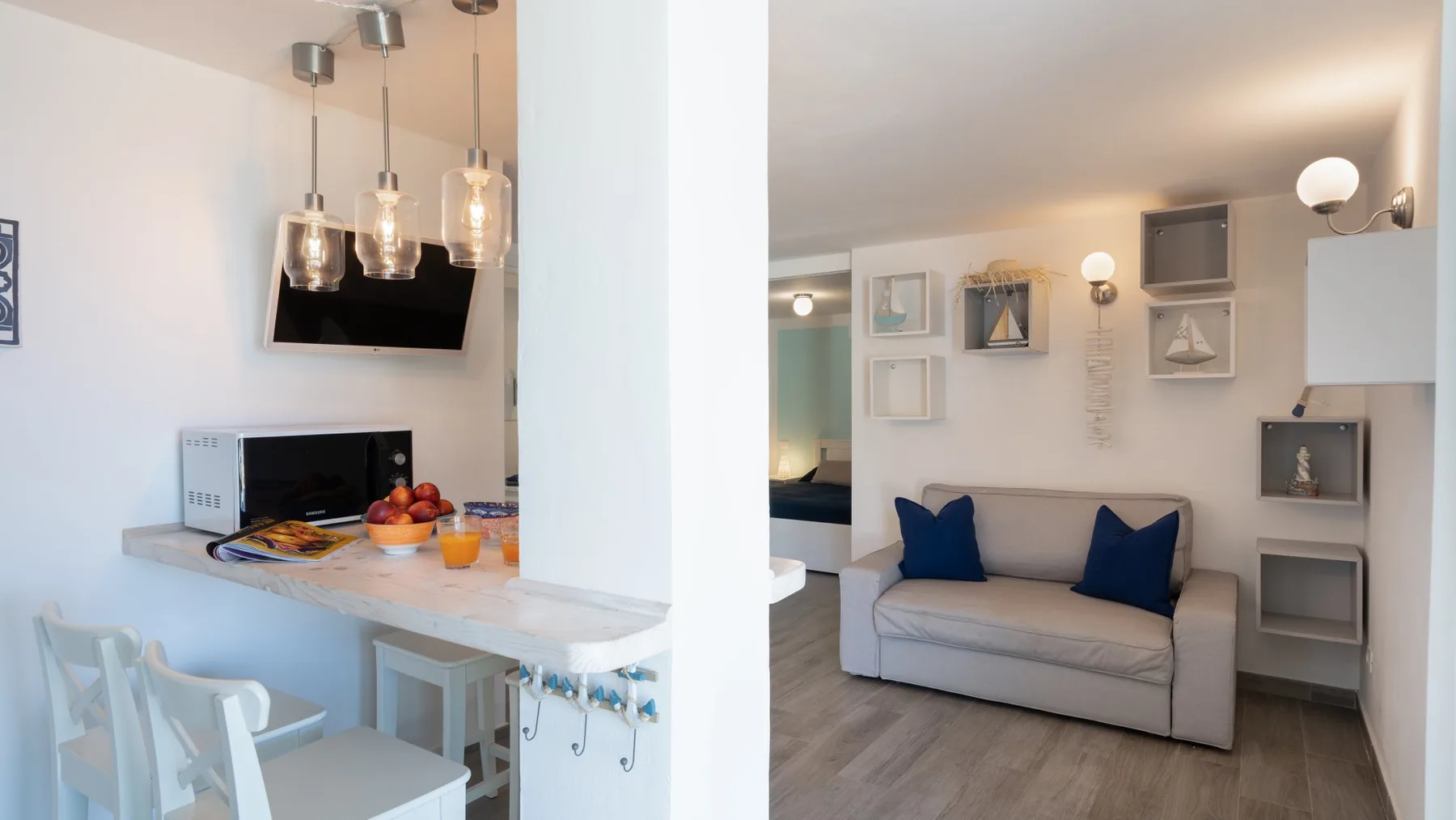Una sala-comedor de planta abierta tiene un sofá junto a una barra.