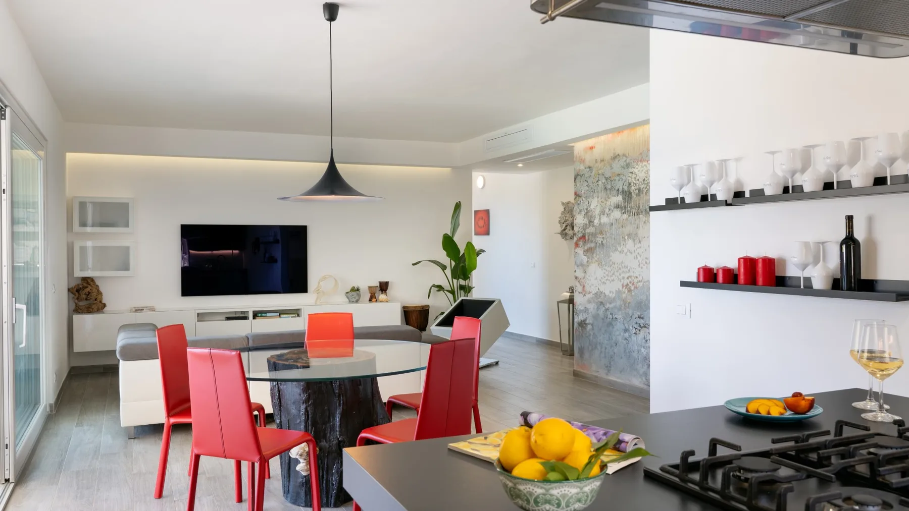 Una sala-comedor de planta abierta con sillas rojas y una isla de cocina.