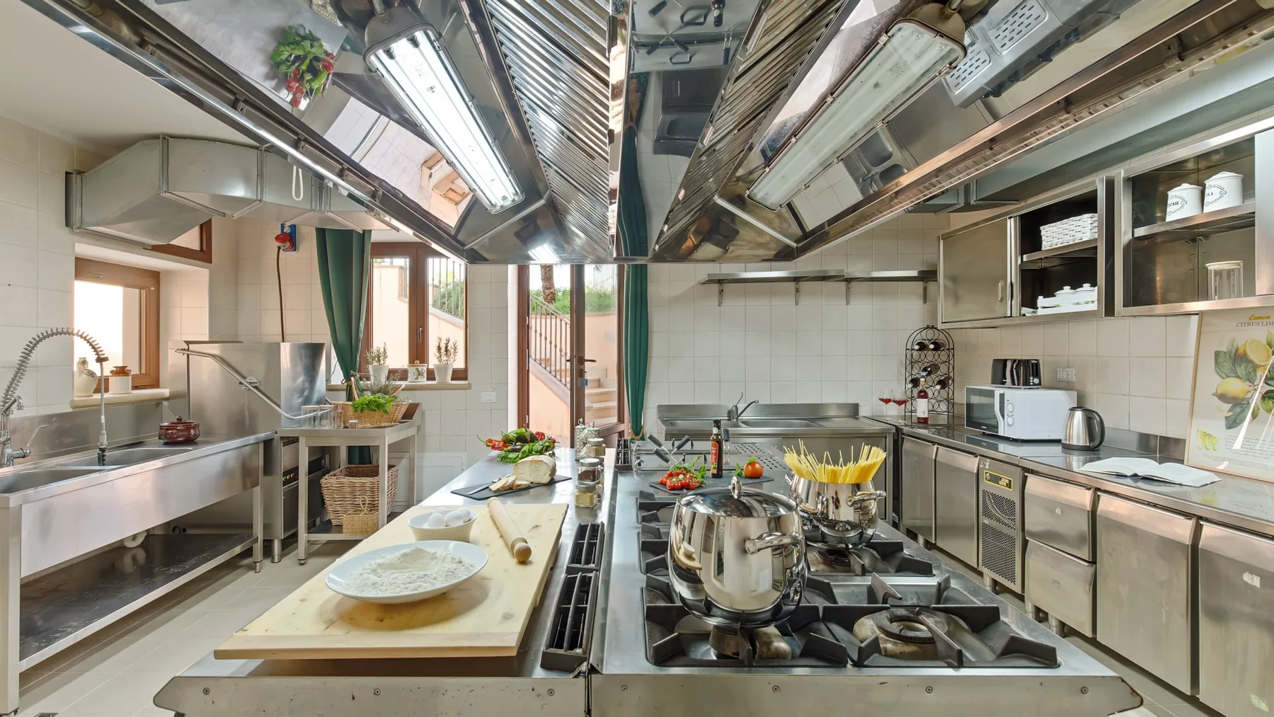 A commercial kitchen with stainless steel counters and cooking equipment.