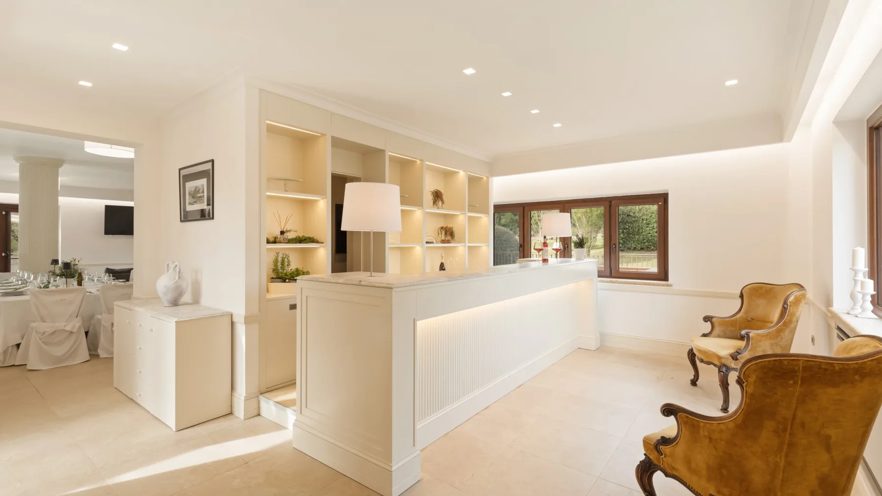 A bright reception area with a long counter, built-in shelves, and seating.