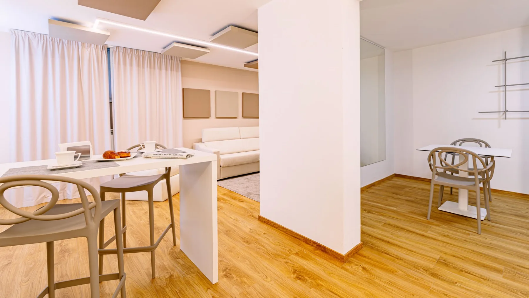 Una sala-comedor abierta con una mesa blanca y asientos.