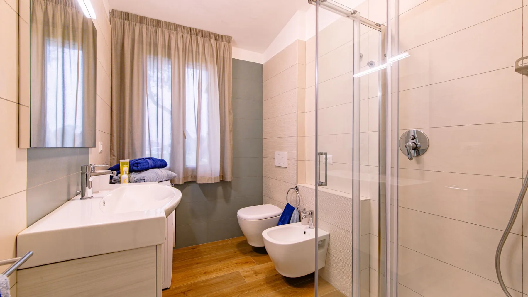 Un baño con lavabo, inodoro, bidé y ducha de cristal.