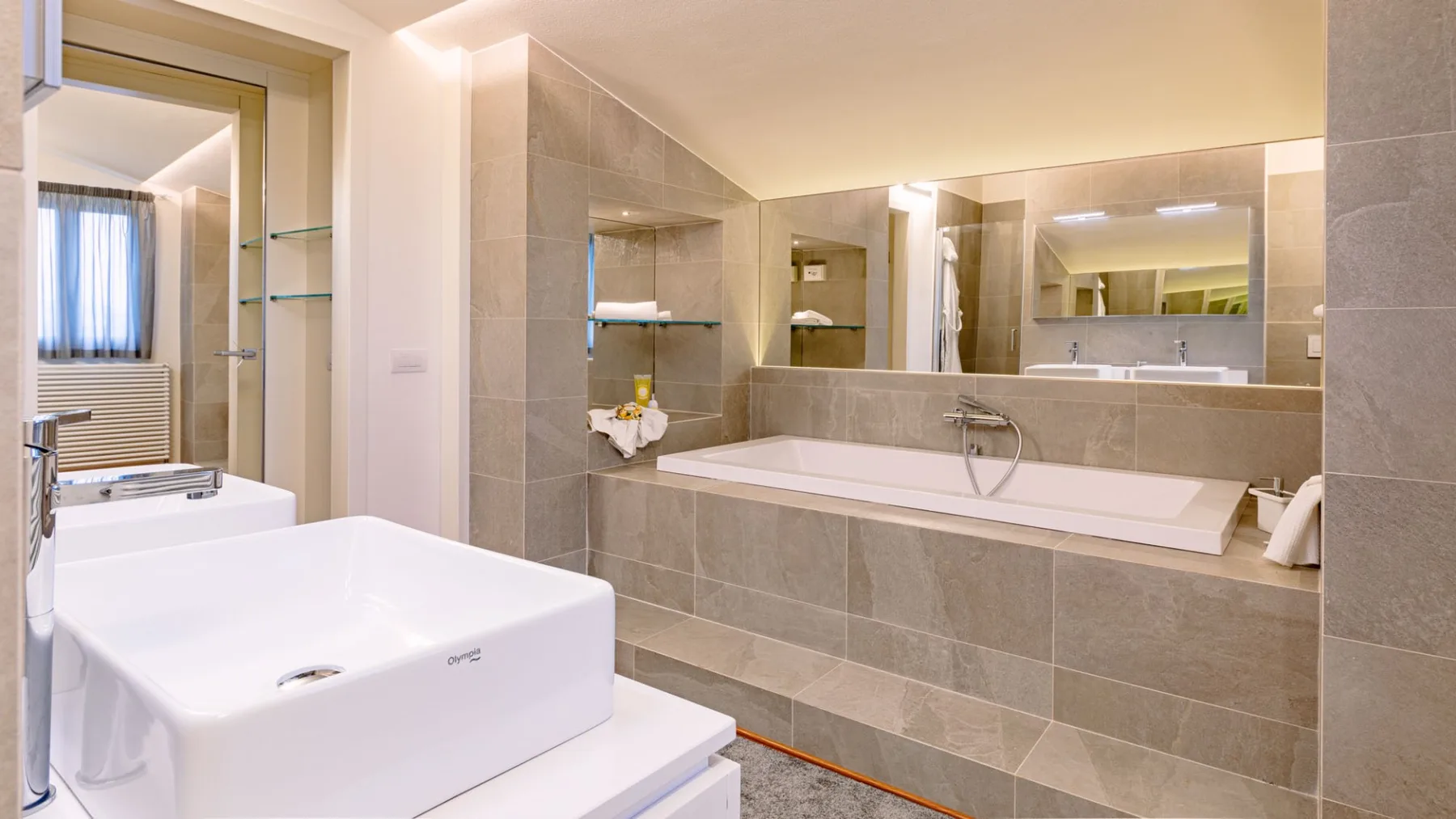 Un baño con una bañera y un espejo grande.