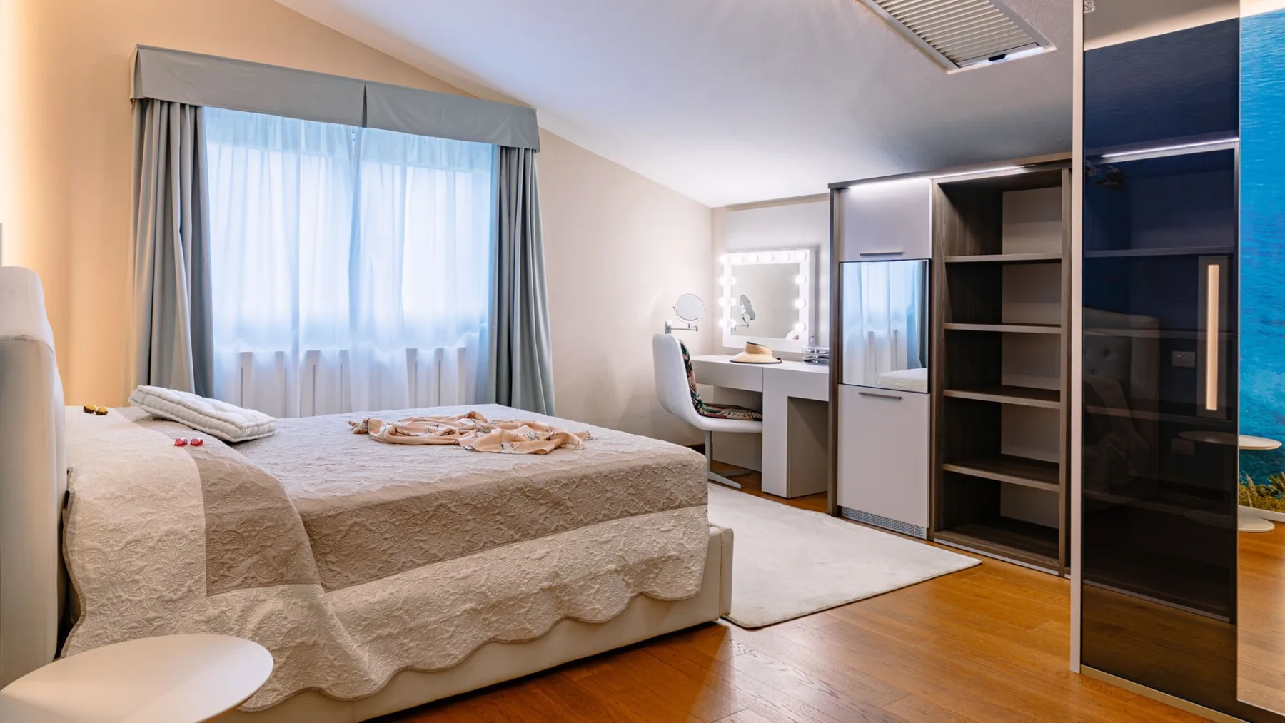 Un dormitorio con una cama junto a una ventana y un escritorio integrado.