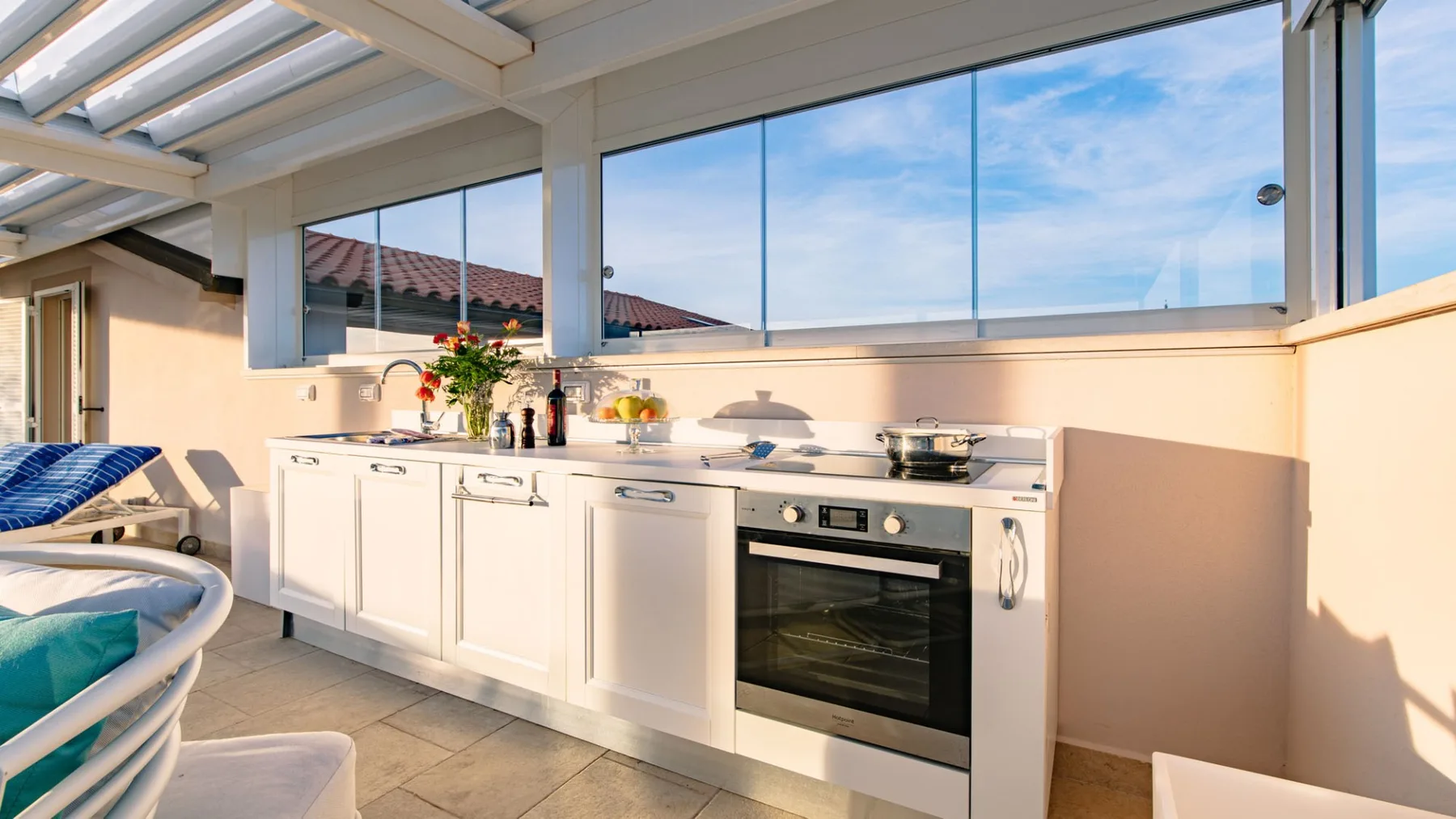 Una cocina luminosa con gabinetes blancos, un horno y ventanas amplias.