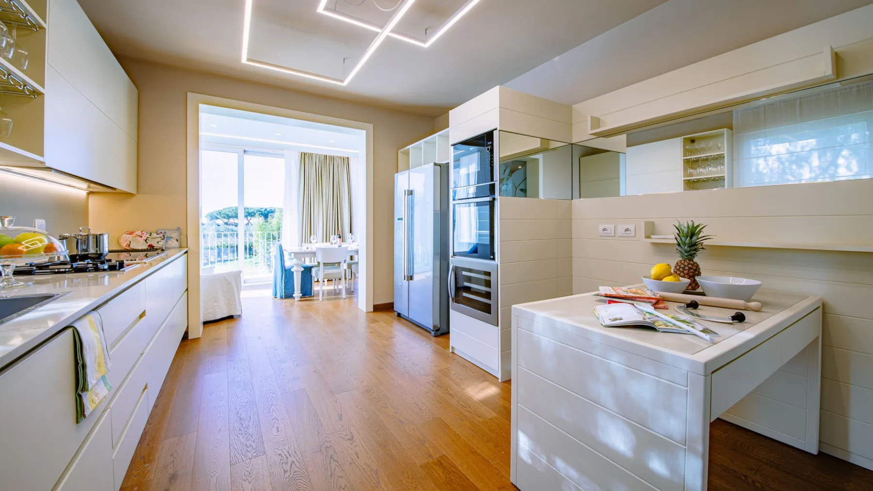 Una cocina moderna y luminosa con gabinetes blancos y una isla central.