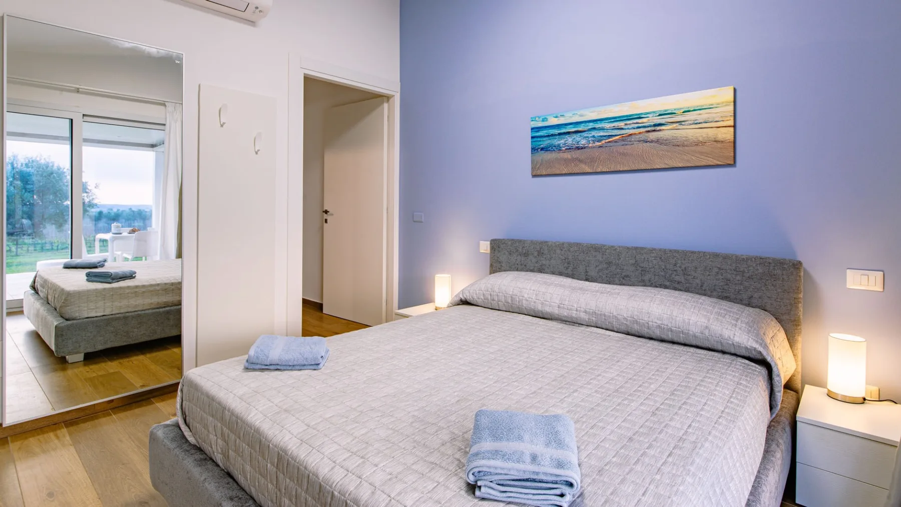 Un dormitorio con una cama grande y un cuadro en la pared.