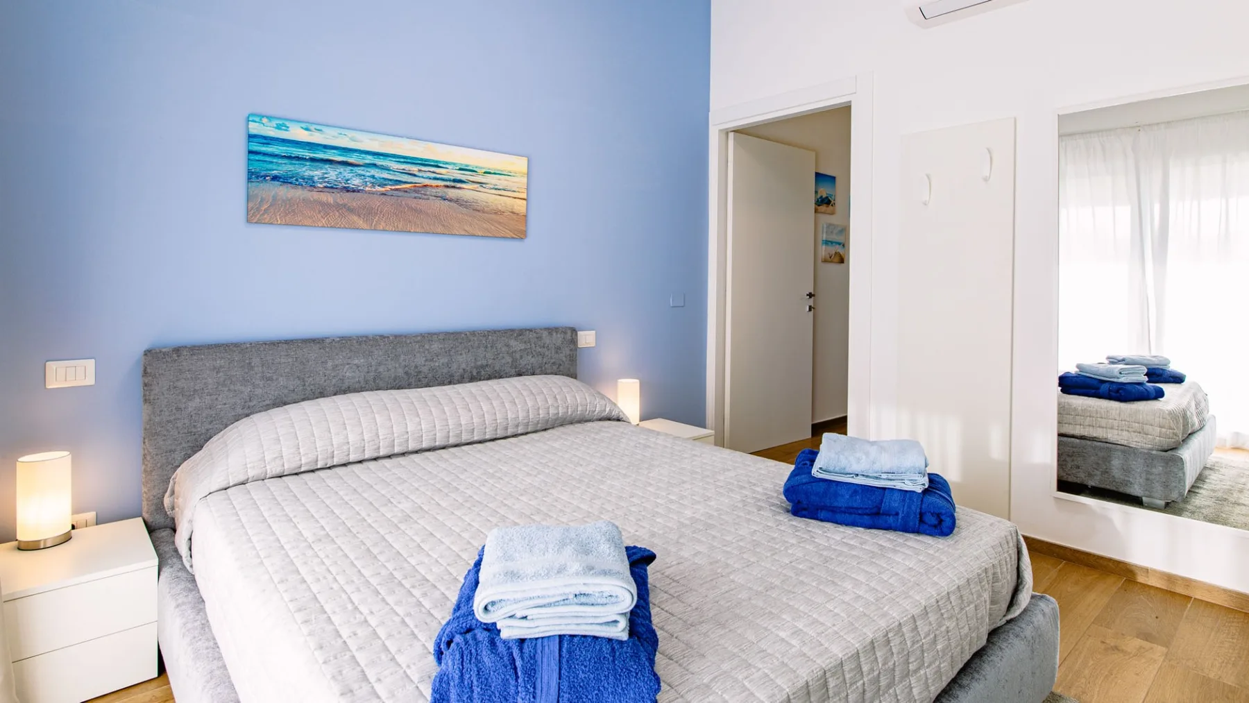 Un dormitorio con una cama bien hecha y toallas azules.