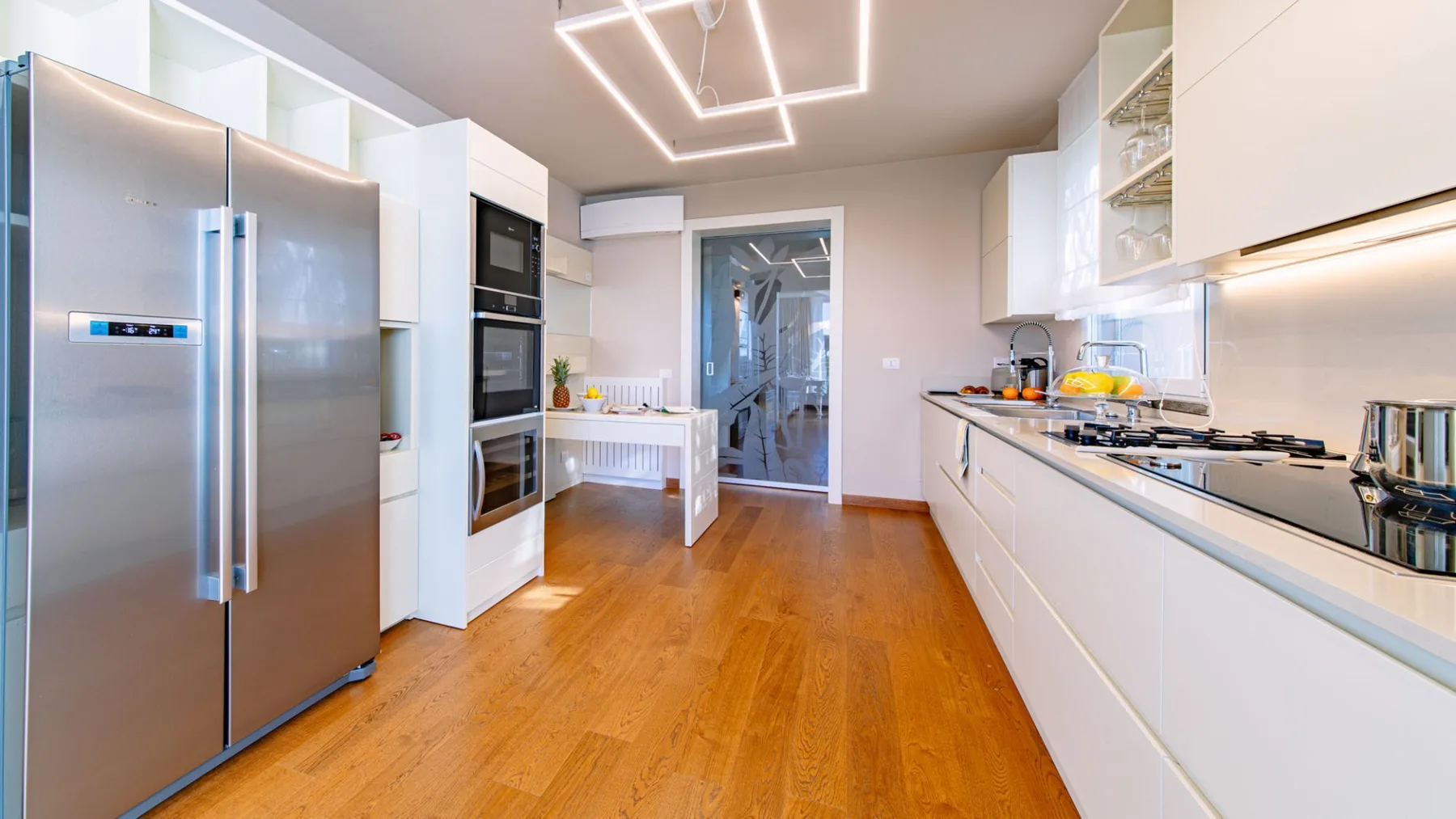Una cocina moderna con electrodomésticos de acero inoxidable y gabinetes blancos.