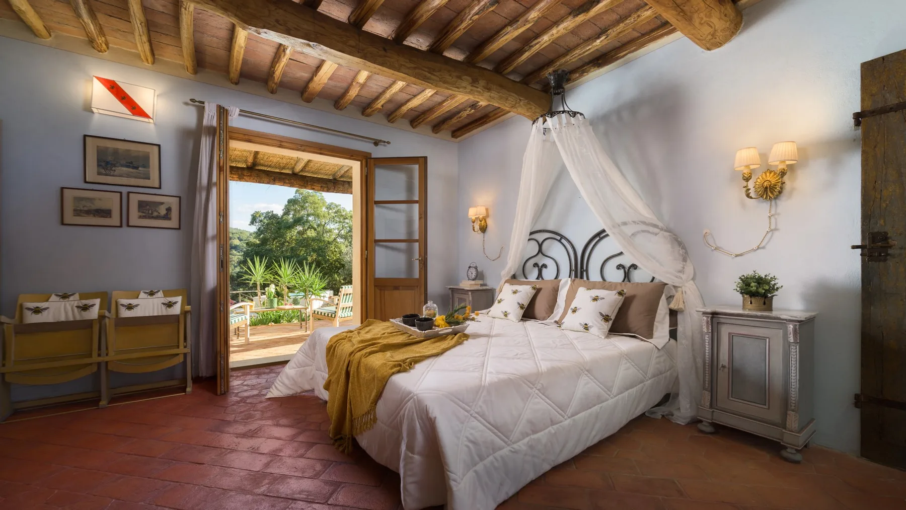Un dormitorio con cama con dosel y una puerta abierta al jardín.
