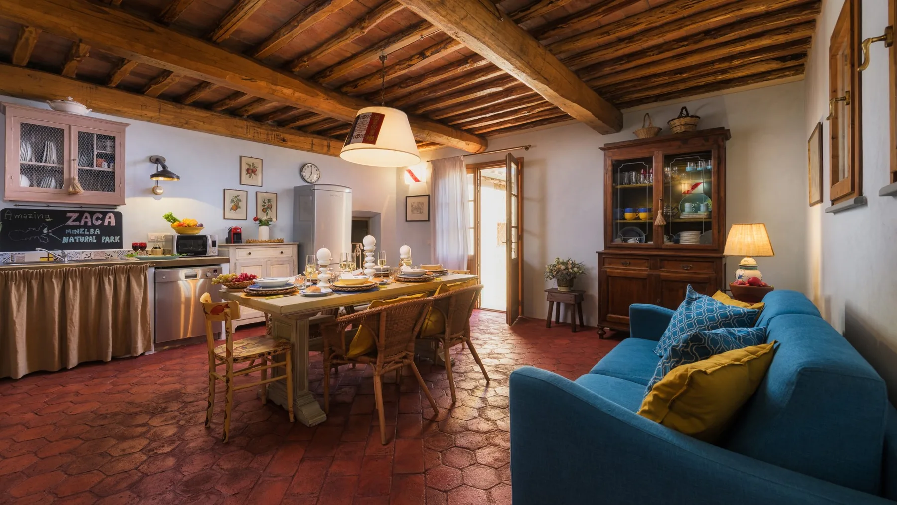 Un salón rústico con comedor, una mesa larga y asientos azules.