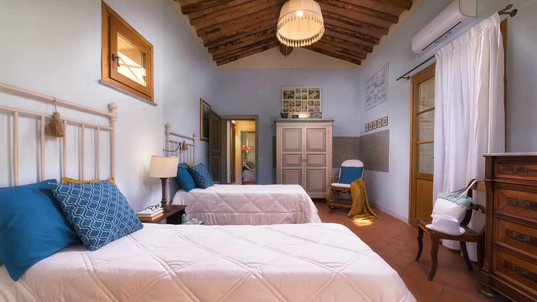 Un dormitorio con dos camas bajo un techo de madera inclinado.