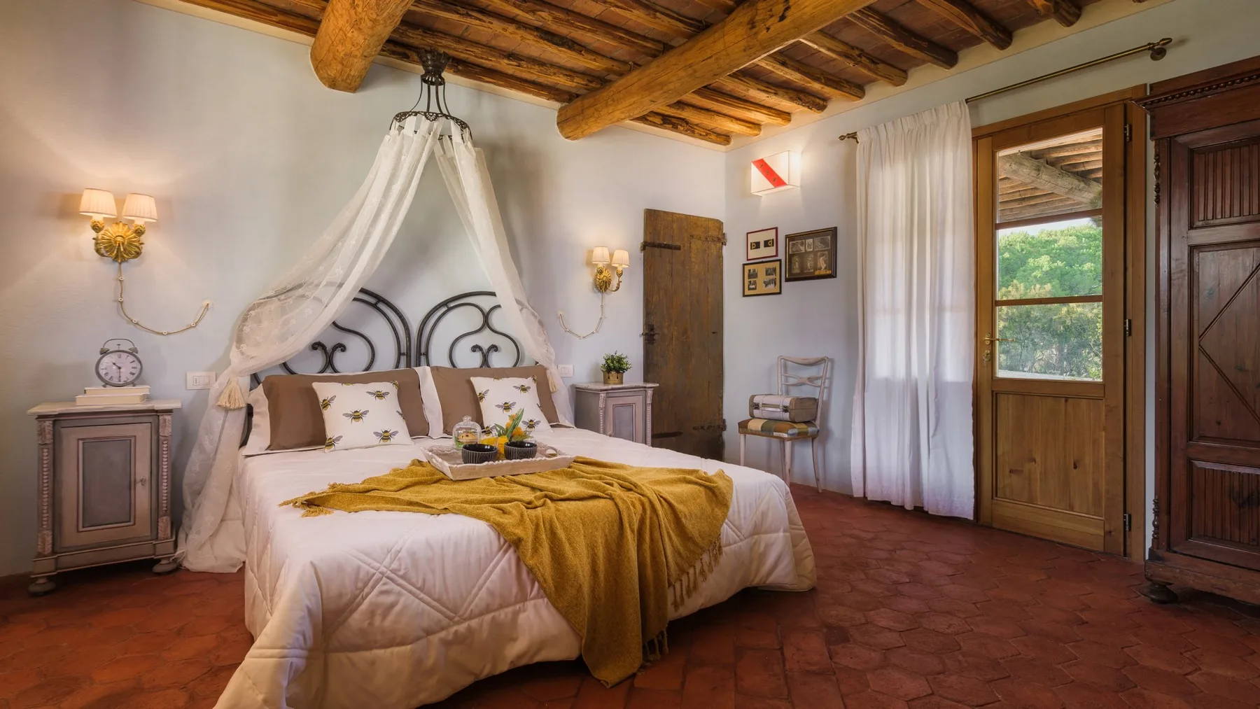 Un dormitorio con una cama con dosel y vigas de madera a la vista.