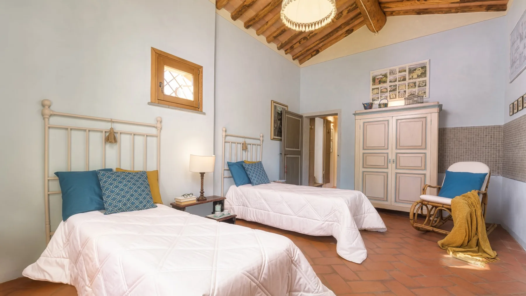 Un dormitorio con dos camas, un techo de madera y un armario grande.
