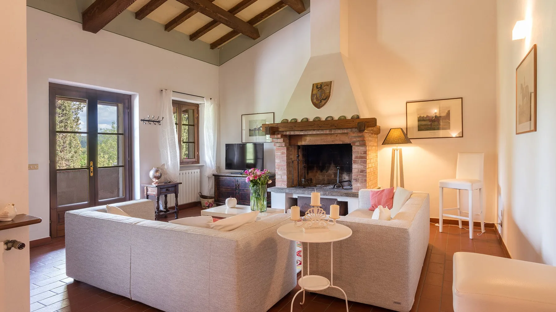 Una luminosa sala de estar con asientos dispuestos alrededor de una chimenea.