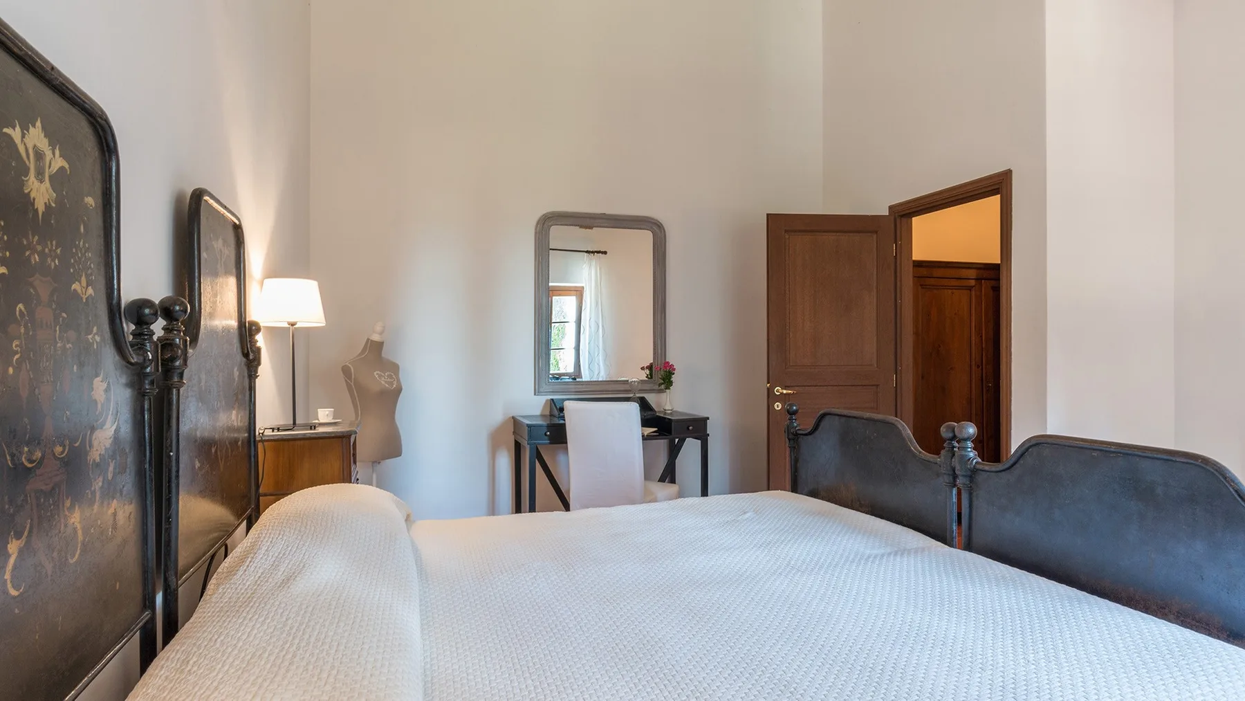 Un dormitorio con una cama, un escritorio y una puerta abierta.