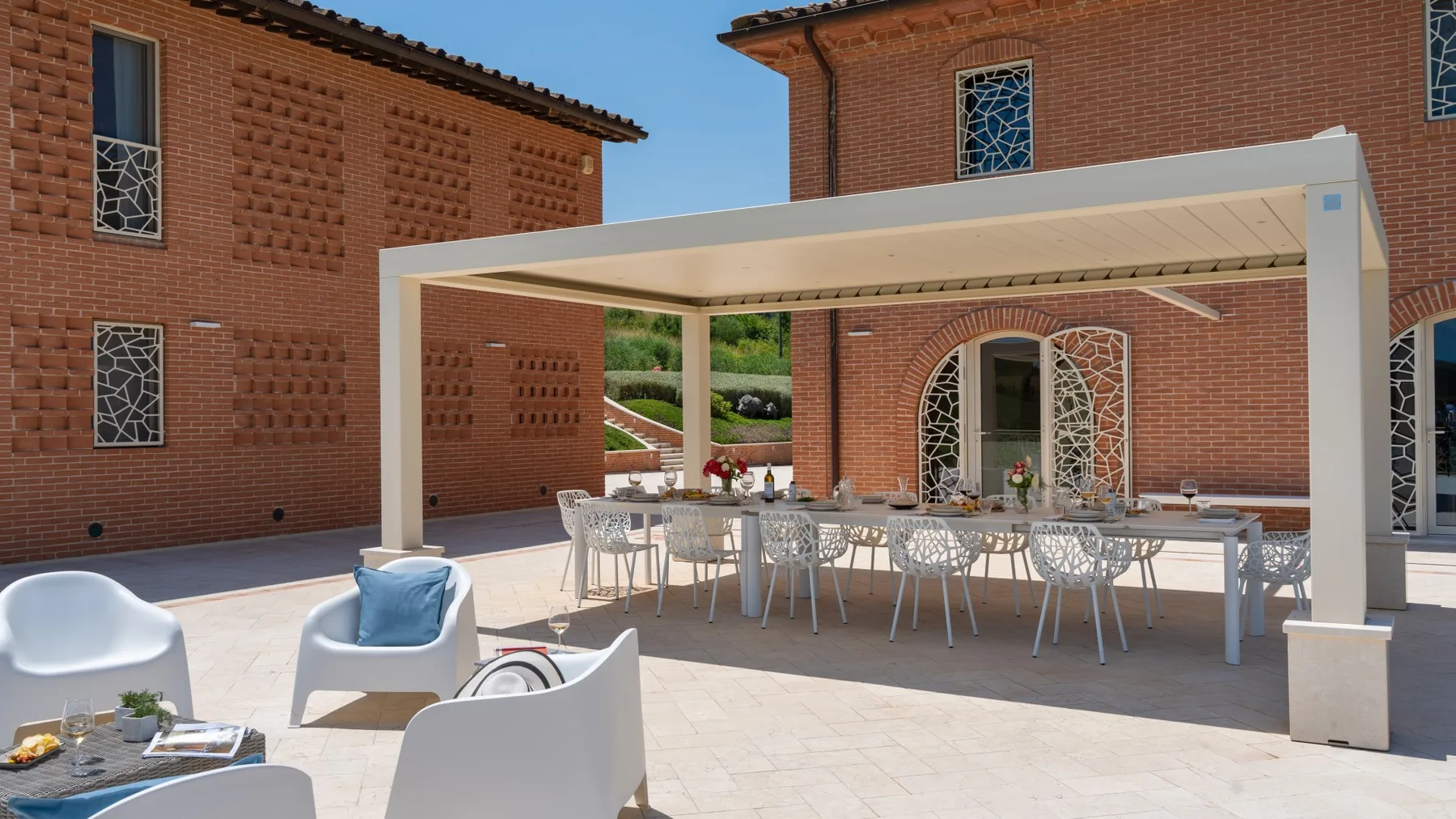 A brick courtyard with a covered dining area and outdoor seating.