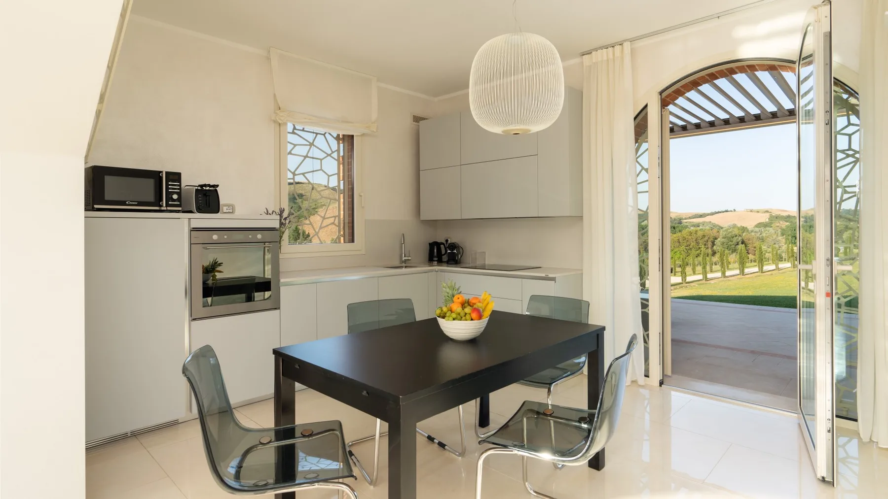 A bright kitchen and dining area opens onto a patio through glass doors.