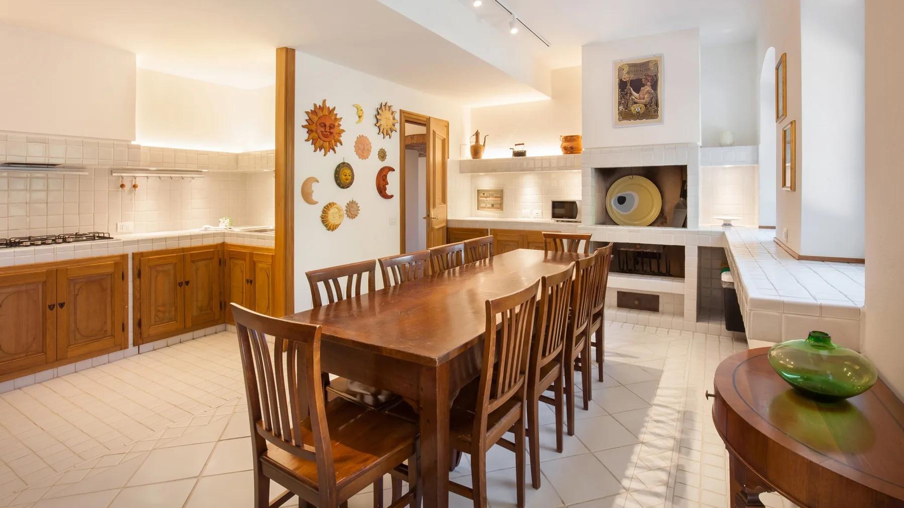A spacious kitchen and dining area with a long wooden table and built-in shelves.