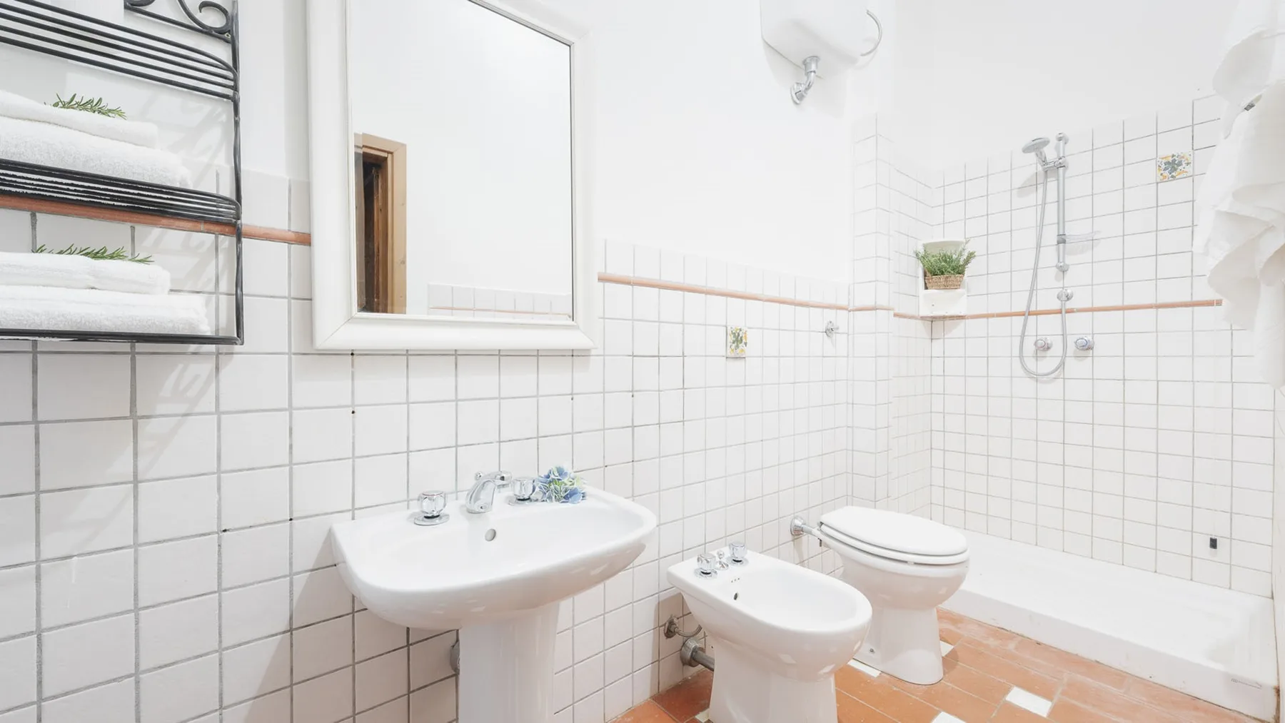 Un baño alicatado con lavabo, inodoro y ducha.
