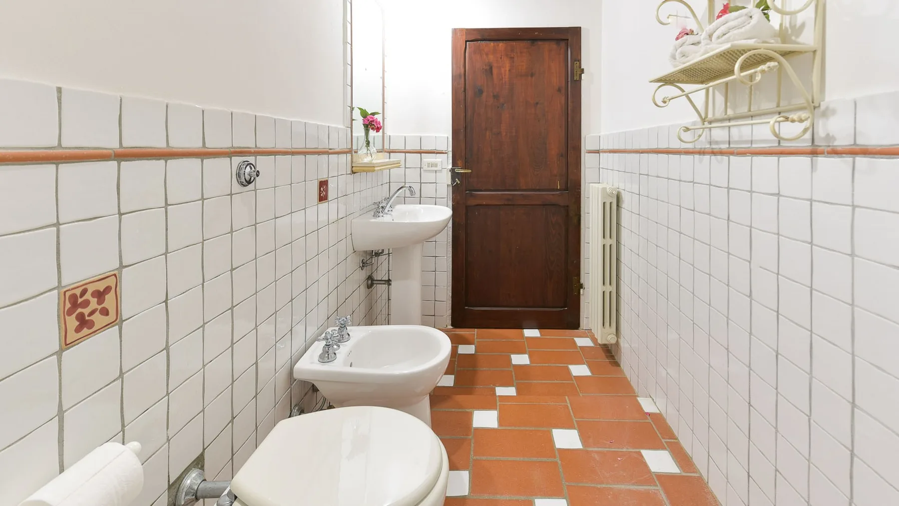 Un baño con azulejos, lavabo y grifería de ducha.
