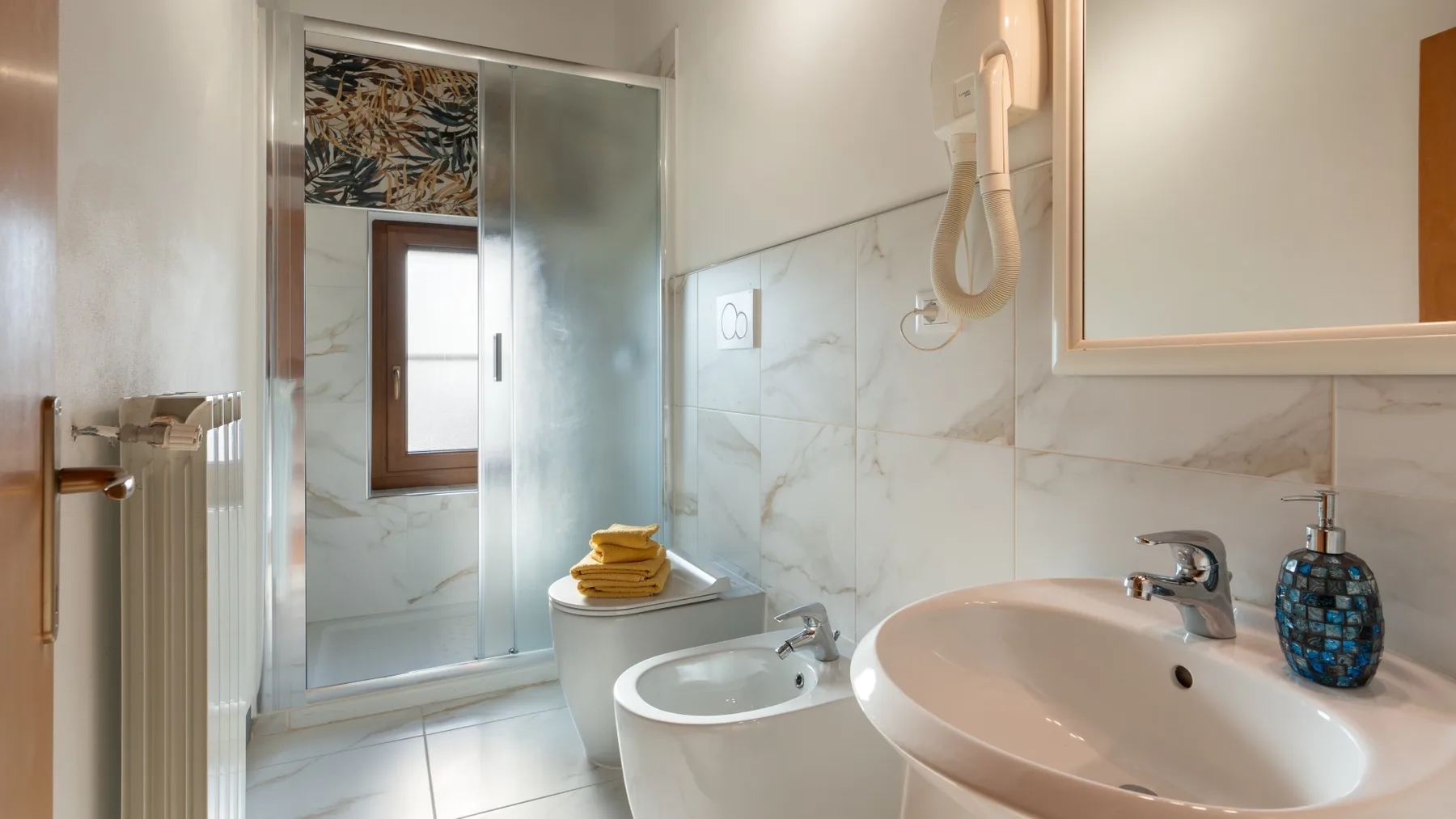 A bright bathroom with a bathtub, sink, and tiled walls.