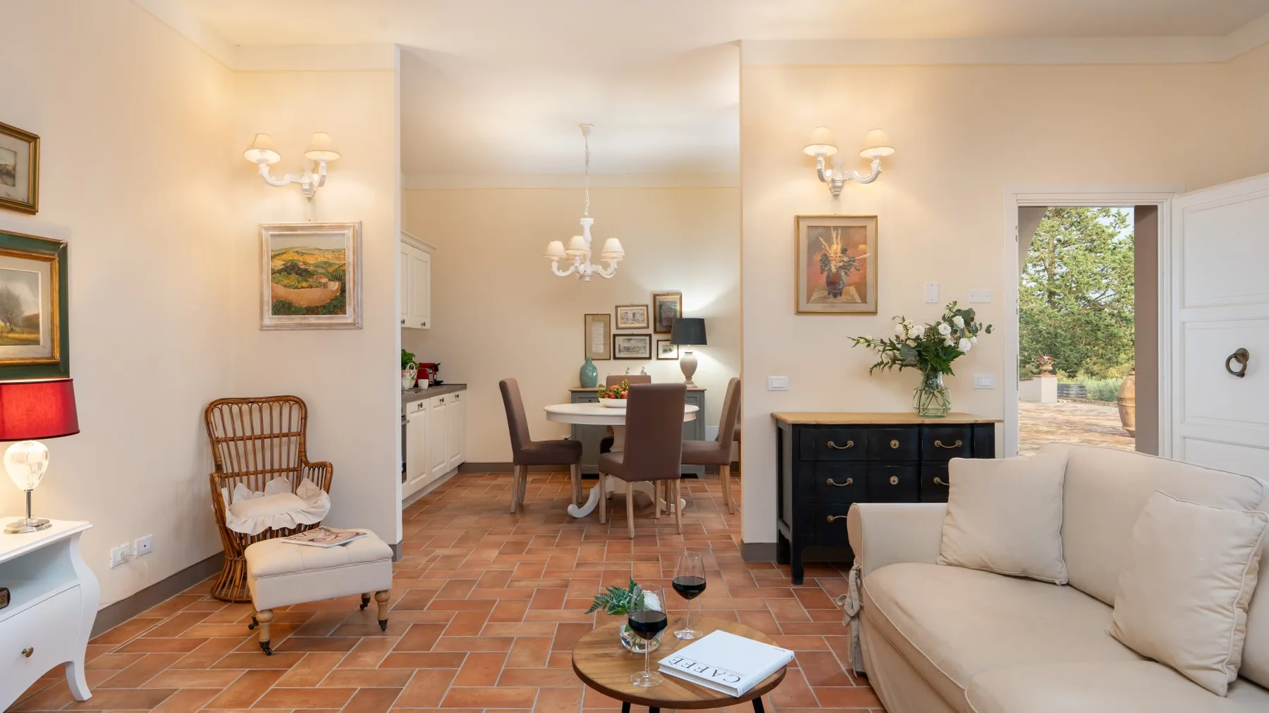 Una luminosa sala de estar y comedor con asientos, una mesa y cuadros enmarcados.