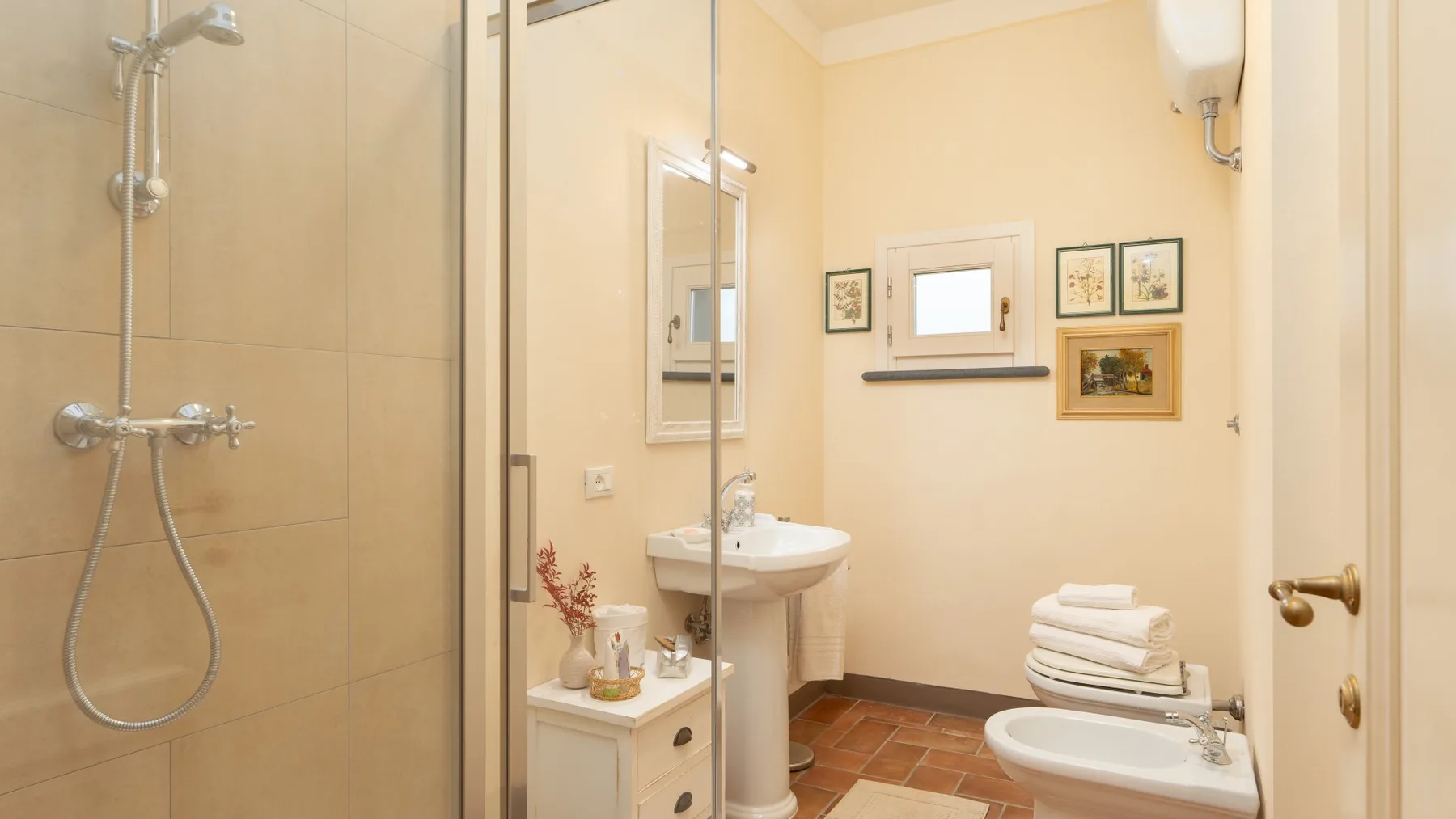 Un baño con ducha de vidrio, lavabo de pedestal y bañera.