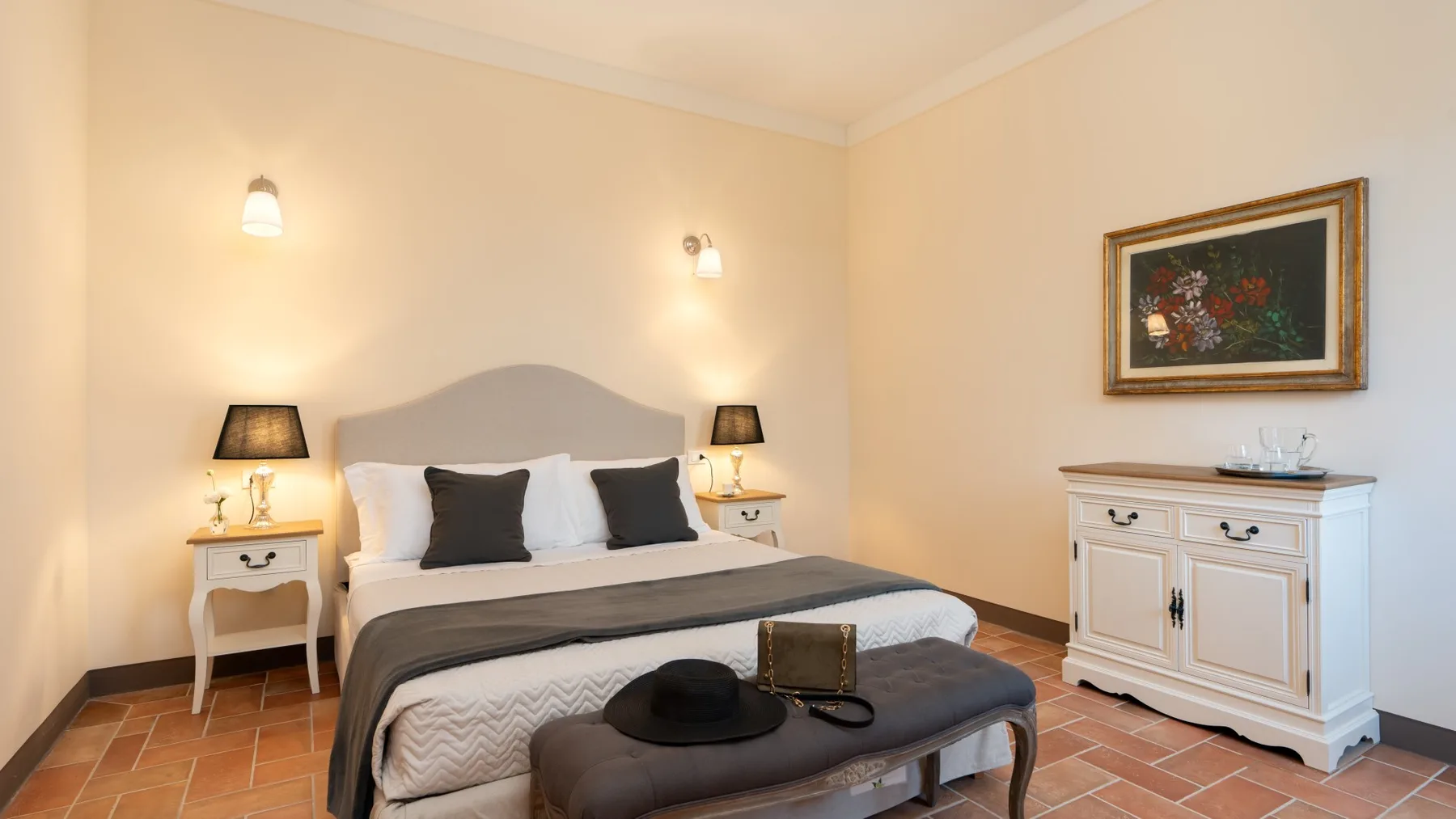 Un dormitorio con cama doble, mesitas de noche y un cuadro enmarcado.