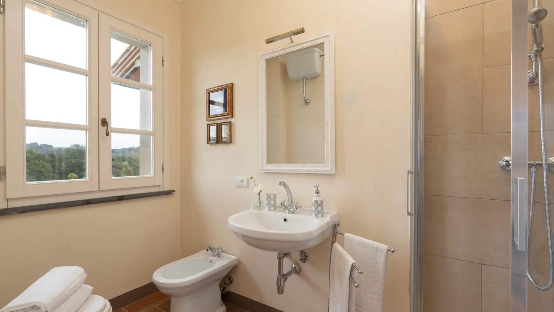 Un baño con lavabo, inodoro y ducha con mampara de vidrio.
