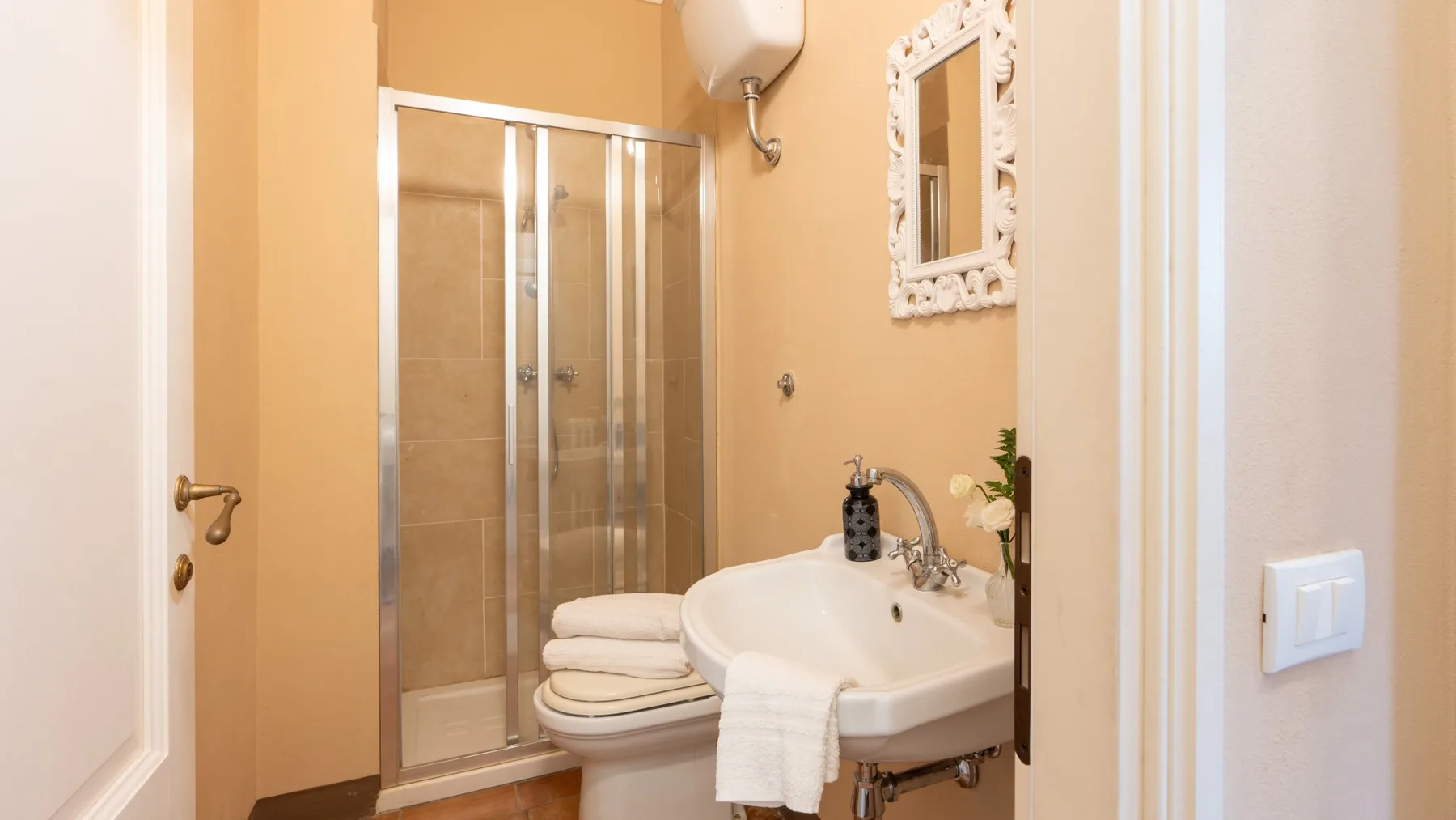 Un baño con ducha, inodoro y lavabo de pared.