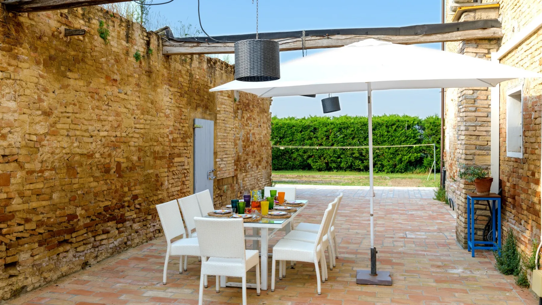 An outdoor dining area with a table and chairs beneath a large white canopy.