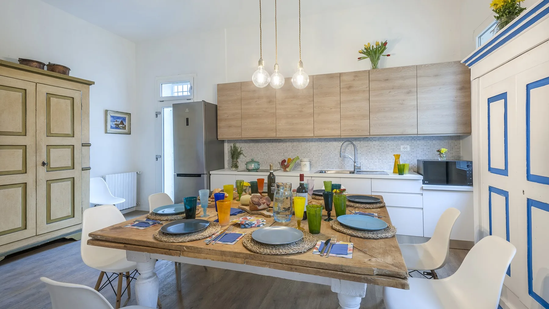 A bright kitchen and dining area with a table set for a meal.