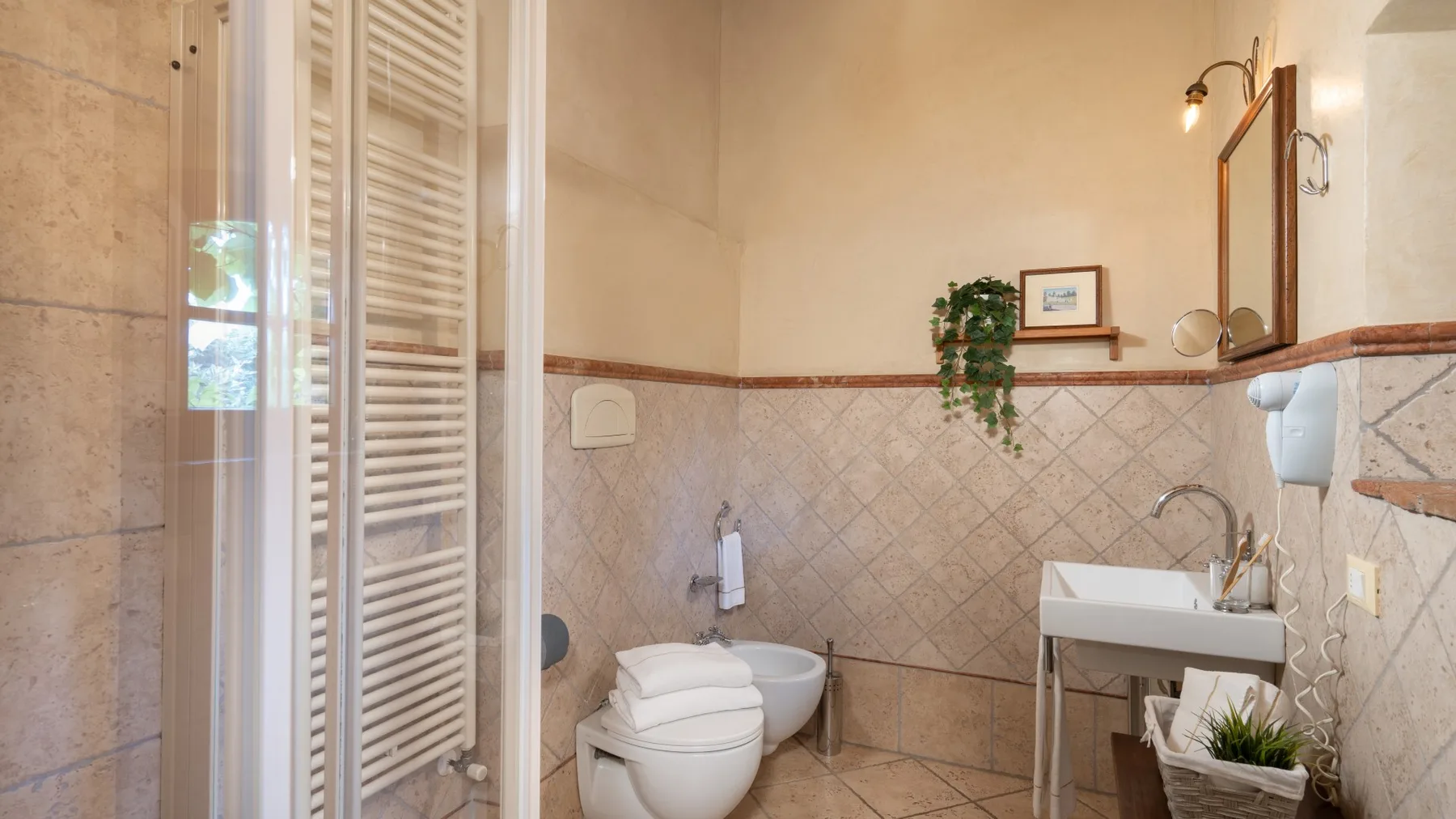 Un baño con inodoro, lavabo y paredes de azulejos.