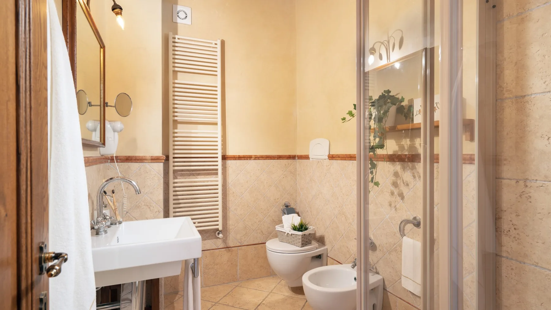 Un baño con lavabo, inodoro, bidé y ducha de cristal.
