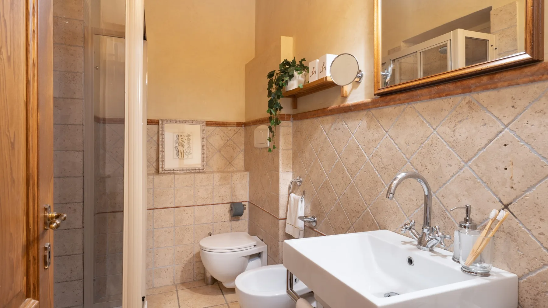 Un baño con lavabo, inodoro y paredes de azulejos.