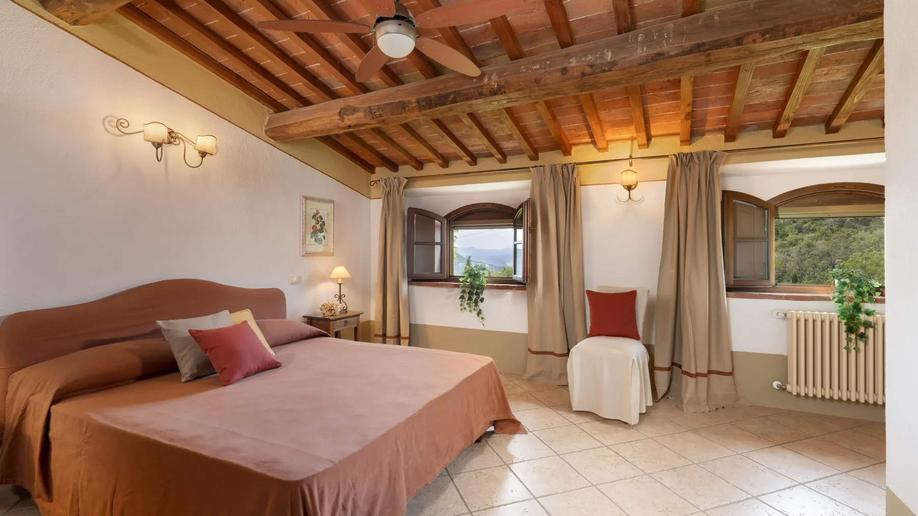 Un dormitorio con una cama, dos ventanas y un techo con vigas de madera.
