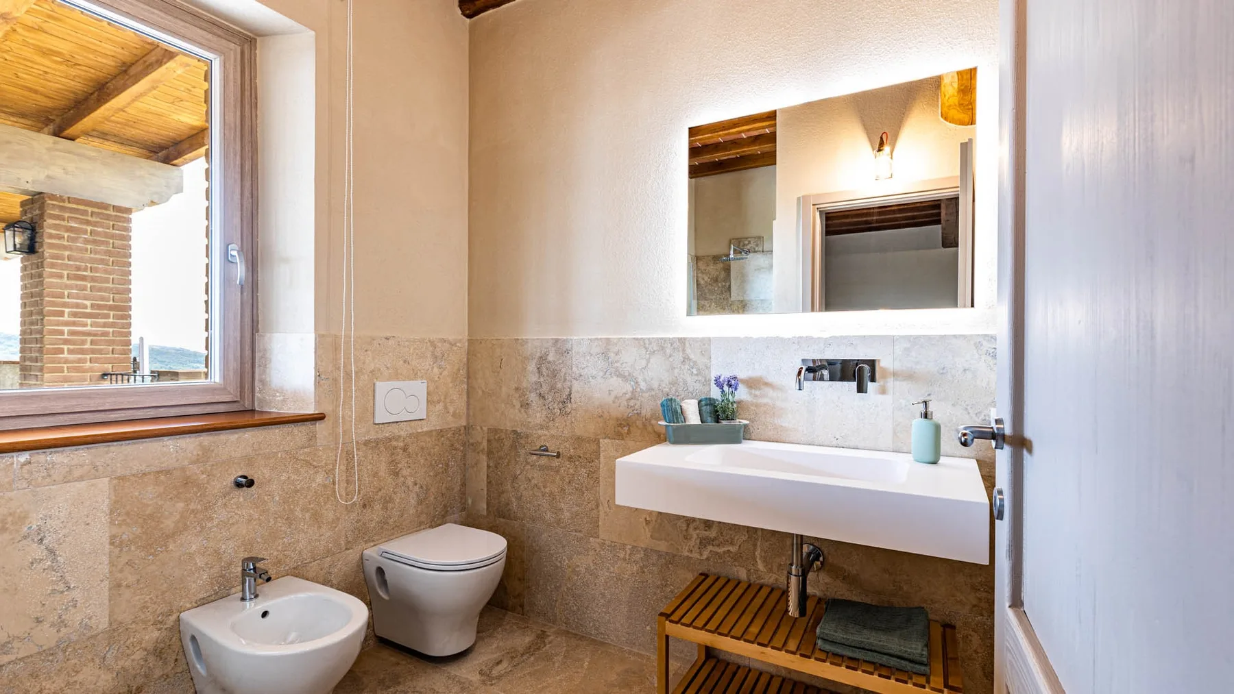 A bathroom with a sink, toilet, and wall mirror.