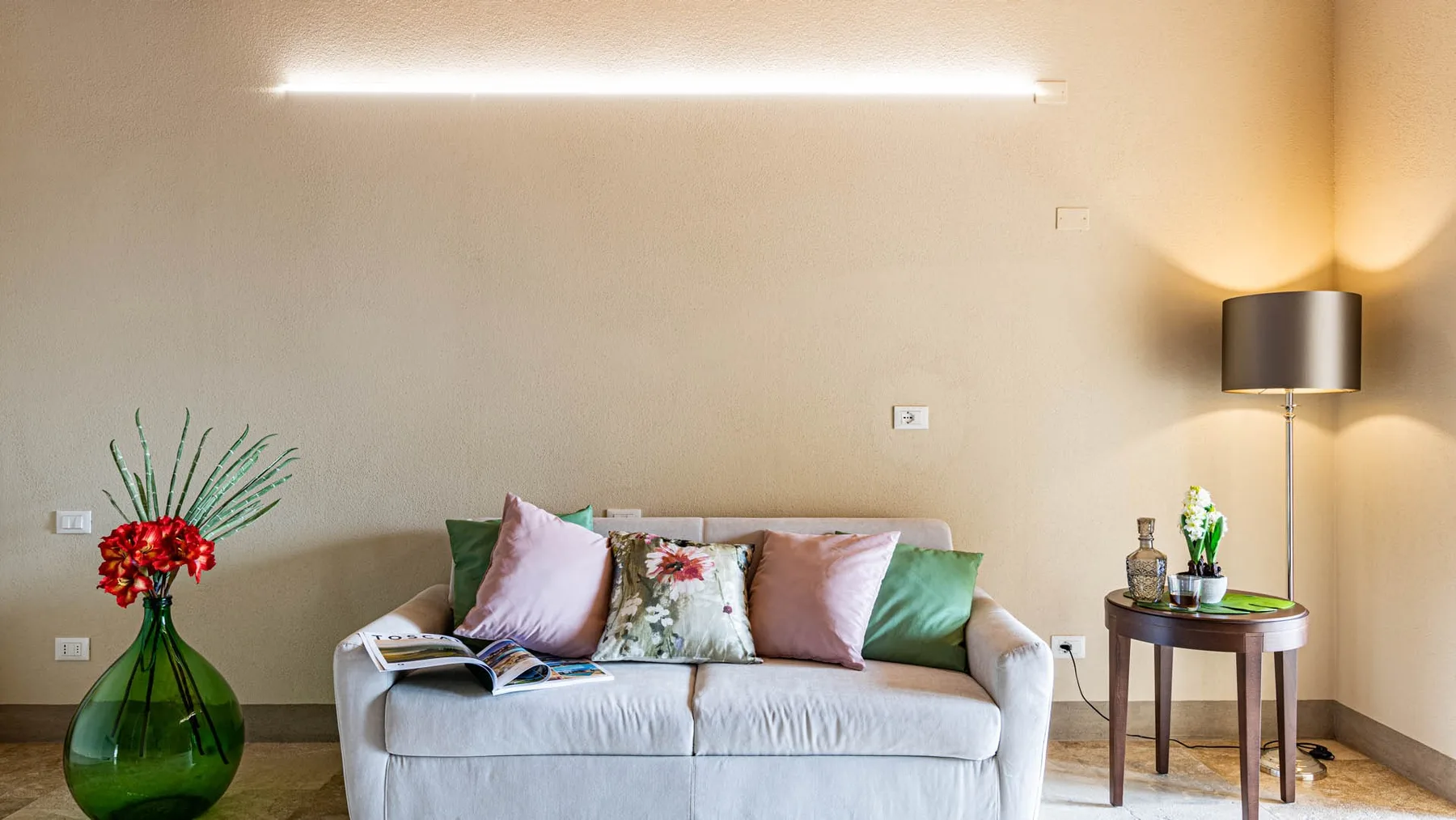 A living room with a light-colored sofa and a side table.