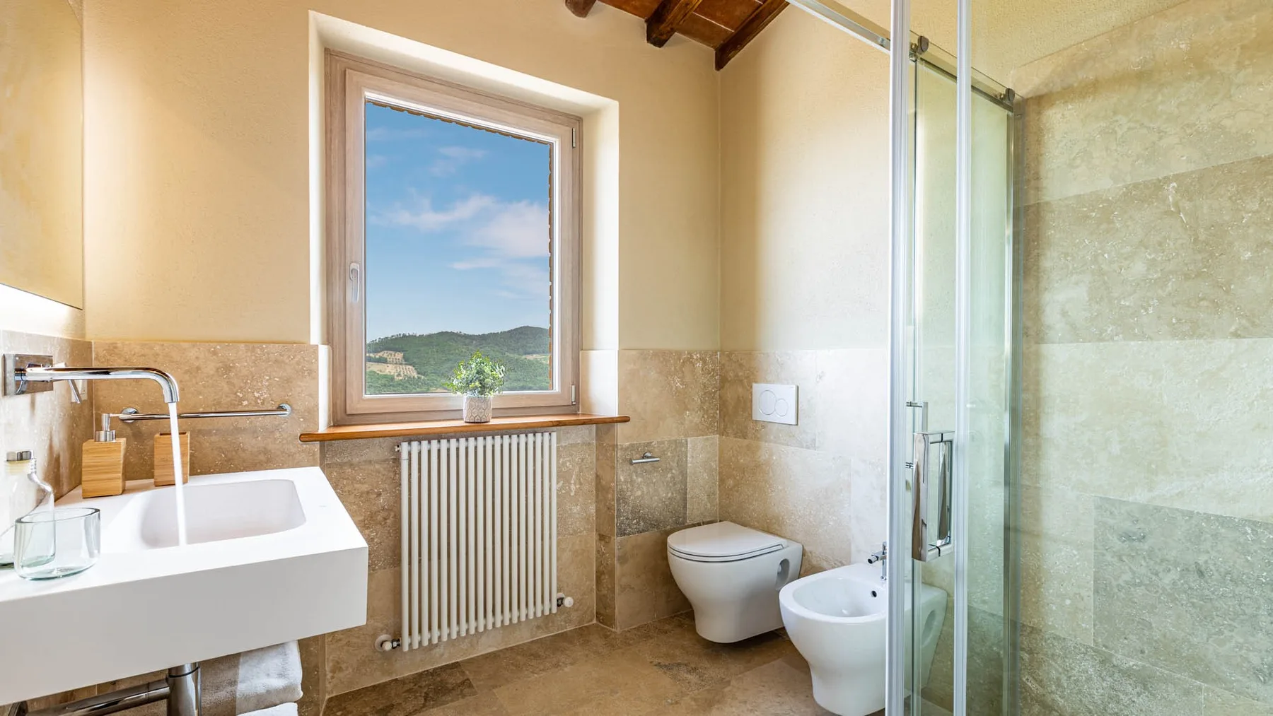 A bathroom with a sink, toilet, and glass-enclosed shower.