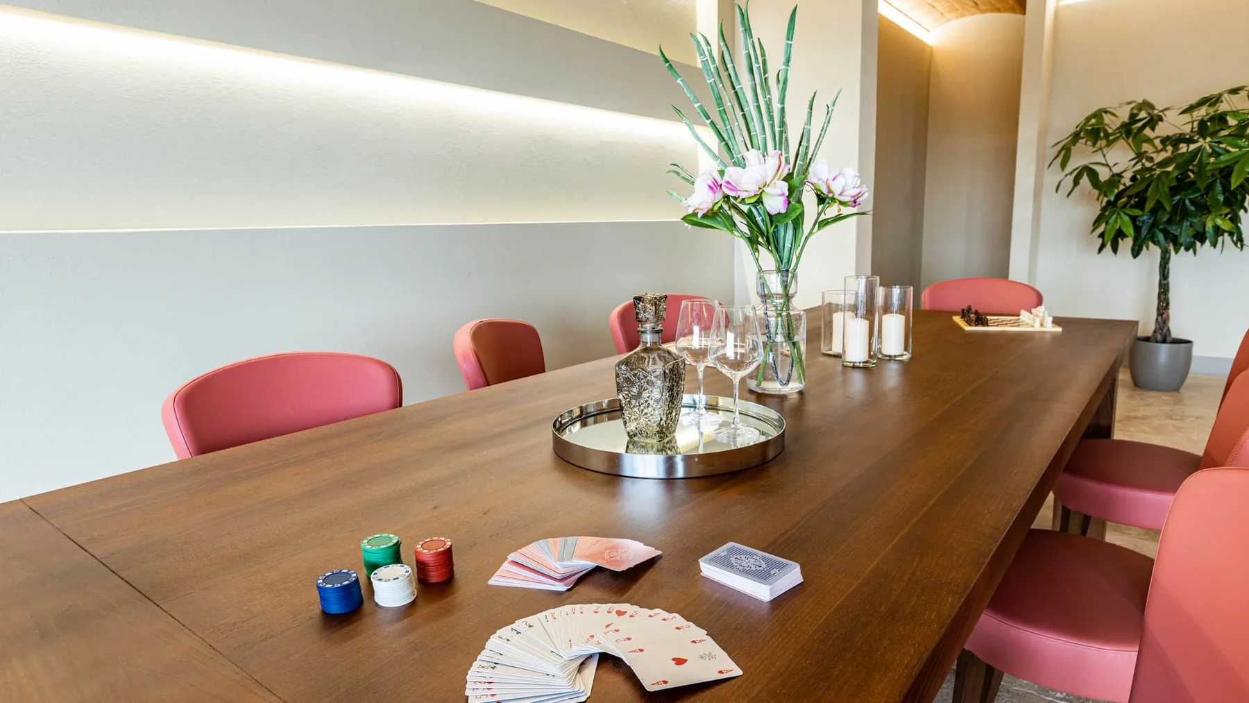 A dining table is arranged with flowers, candles, and place settings.