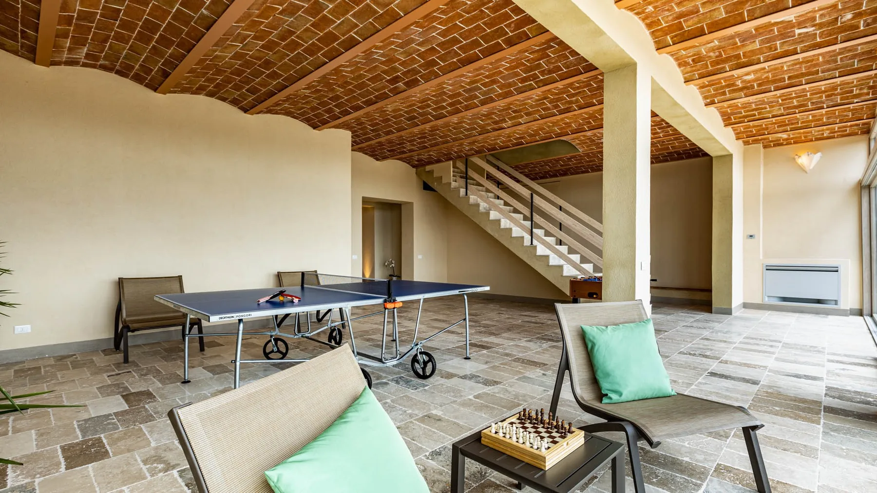 A spacious game room with a billiards table and a chess set.